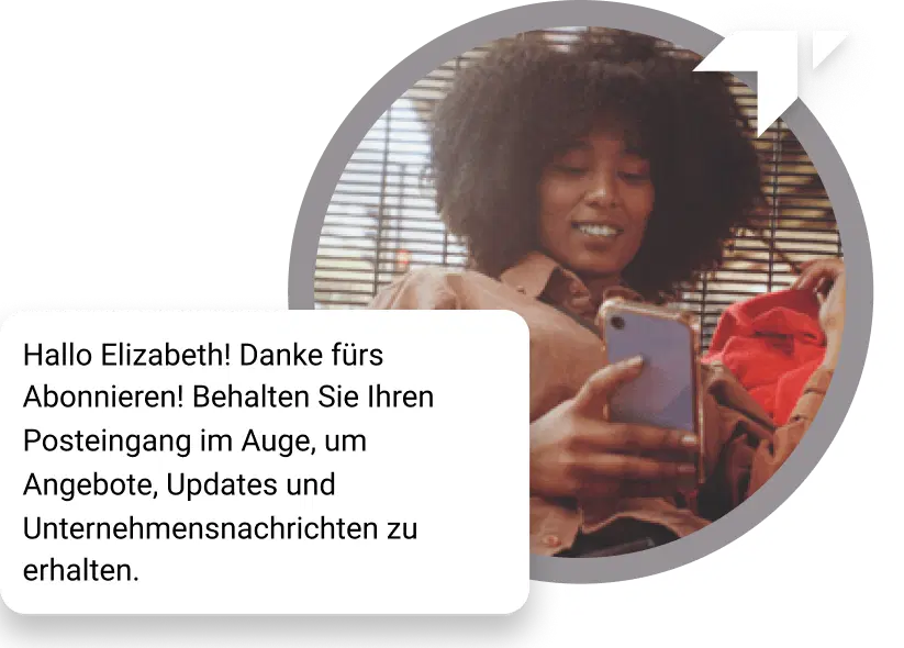 Ein Mädchen mit Locken sitzt auf dem Boden und schaut auf ihrem Handy nach, ob sie eine Dankesnachricht für ihr Abonnement erhalten hat.