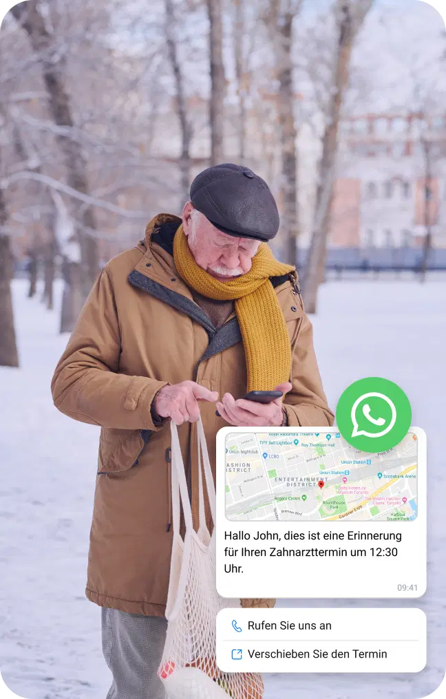Älterer Herr überprüft im Schnee eine WhatsApp-Nachricht zur Standortbestimmung auf seinem Smartphone.