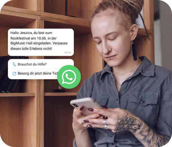Tätowiertes Mädchen checkt eine WhatsApp-Nachricht mit einer Einladung zu einem Rockfestival.