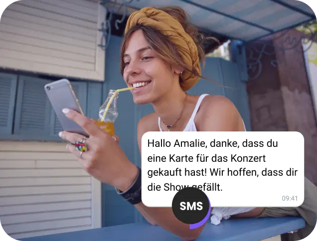 Mädchen trinkt Saft auf der Straße und liest eine SMS-Bestätigung für ein Konzertticket.