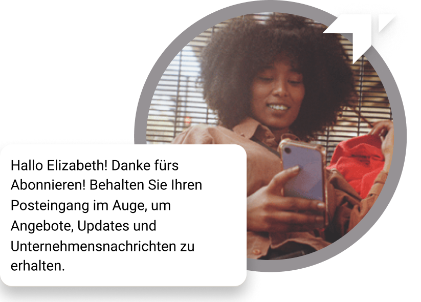 Ein Mädchen mit Locken sitzt auf dem Boden und schaut auf ihrem Handy nach, ob sie eine Dankesnachricht für ihr Abonnement erhalten hat.